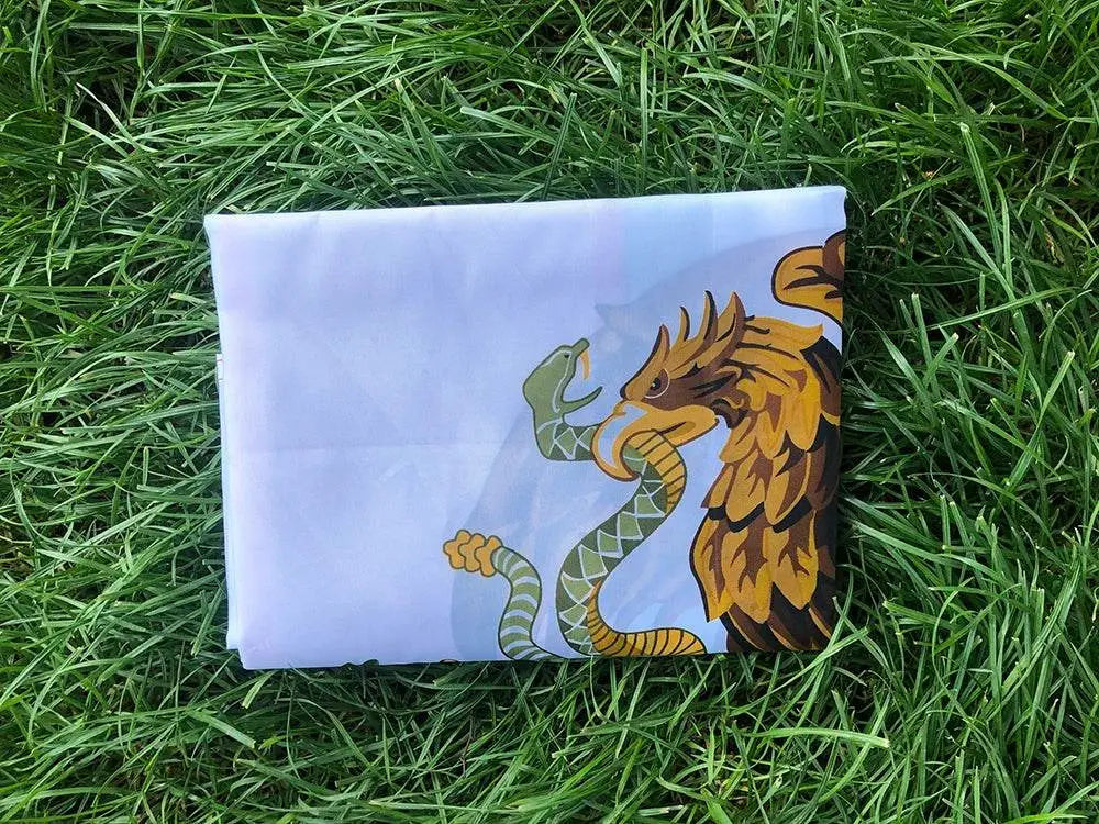 Folded Mexico national flag featuring the eagle and serpent design on green grass