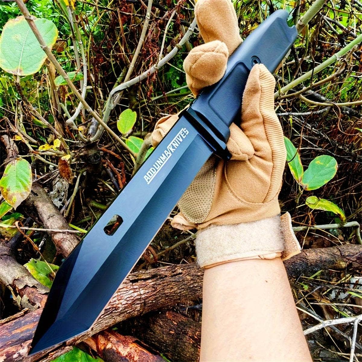 Wilderness survival multi-purpose knife held in a gloved hand, ideal for outdoor adventures