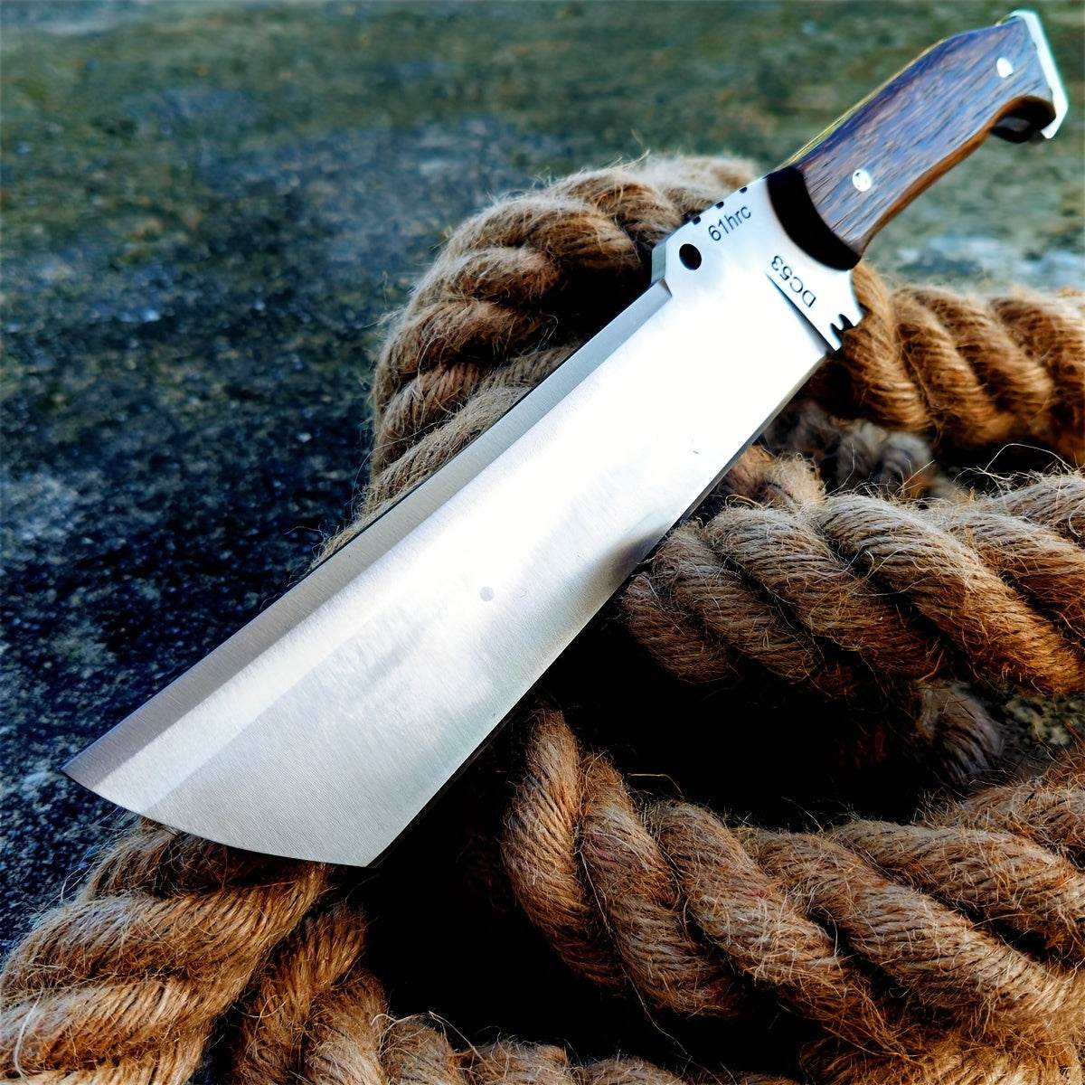 Military Outdoors survival knife with wide cleaver style stainless blade and wood handle on rope