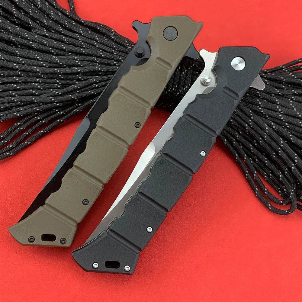 Two professional survival knifes with ergonomic handles in black and olive green, laid on a red background