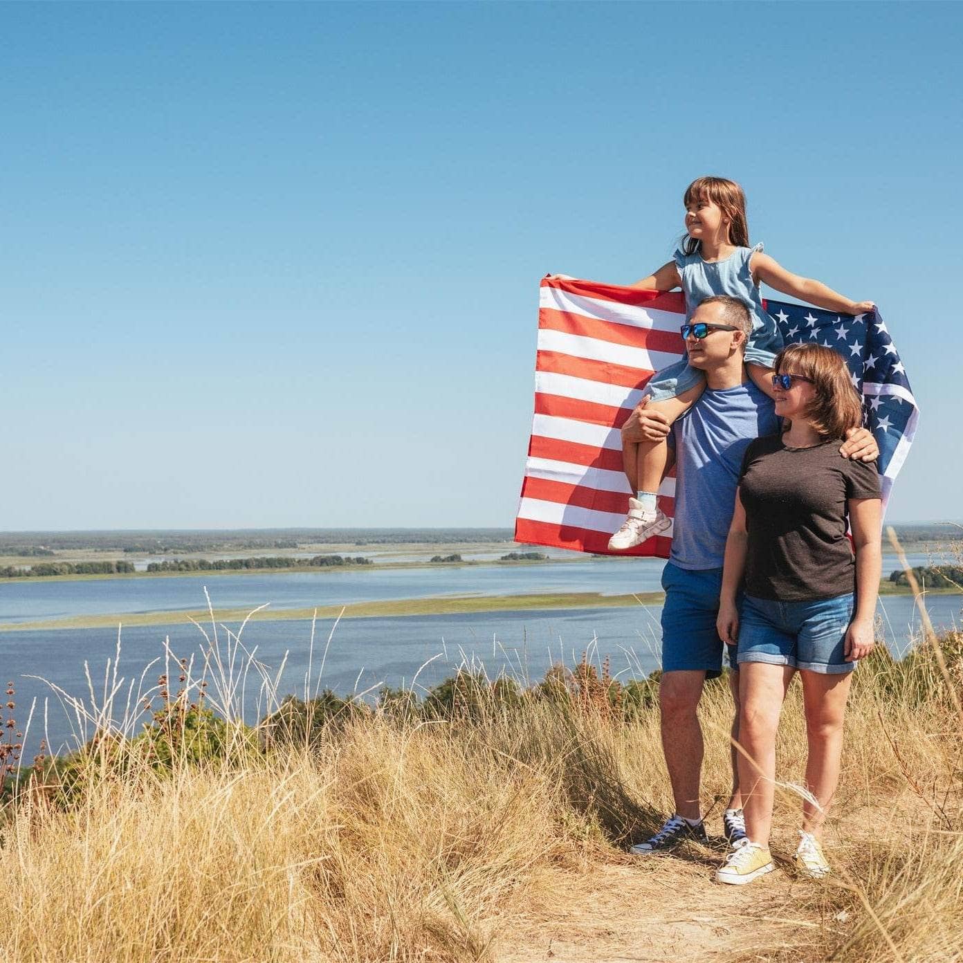 Family enjoying a day outdoors with a USA flag outdoor on a scenic hillside
