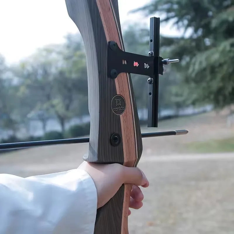 Hand holding a wood recurve bow with a sleek design, ideal for outdoor shooting