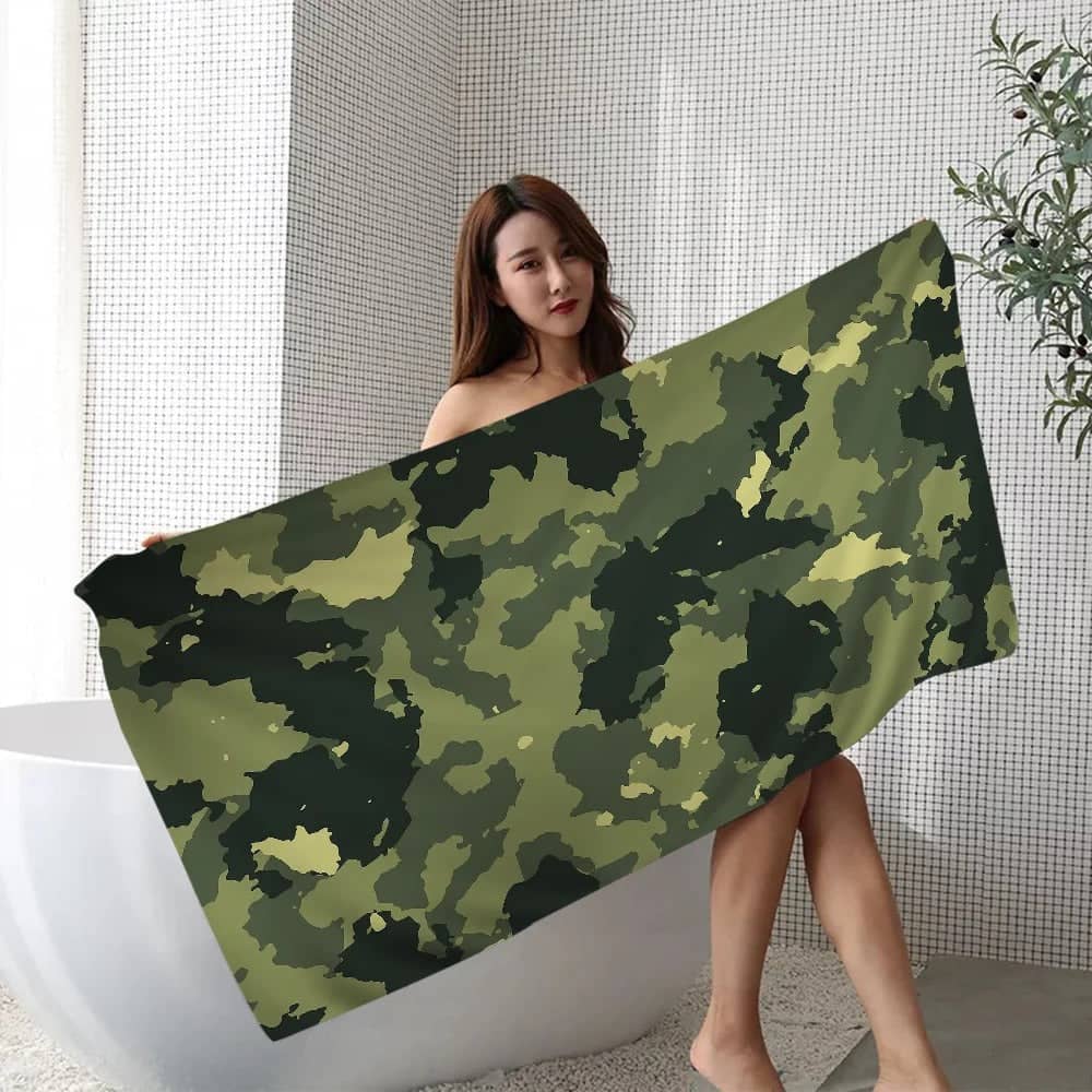 Woman holding a camouflage beach towel in a modern bathroom setting