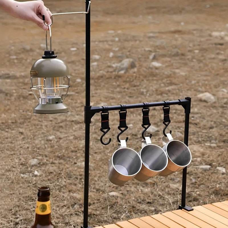 Black camping hanging rack with lantern and three metal mugs for outdoor use