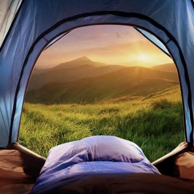 Military-Outdoors Camping Sleeping Bag inside a tent with scenic mountain view at sunset
