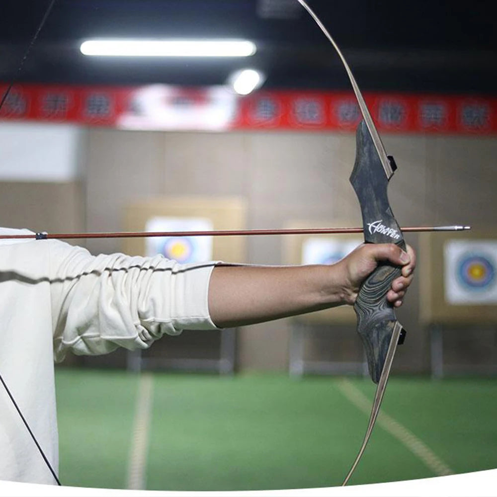 Military-Outdoors hunting recurve bow held by a person with an arrow nocked, ready to shoot