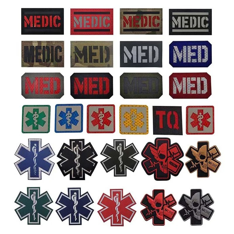 A grid of embroidered tactical medical patches on a white background, featuring the word 'MEDIC' in red, camouflage, and gray, alongside various Star of Life and caduceus emblems in blue, green, red, black, gold, and brown.