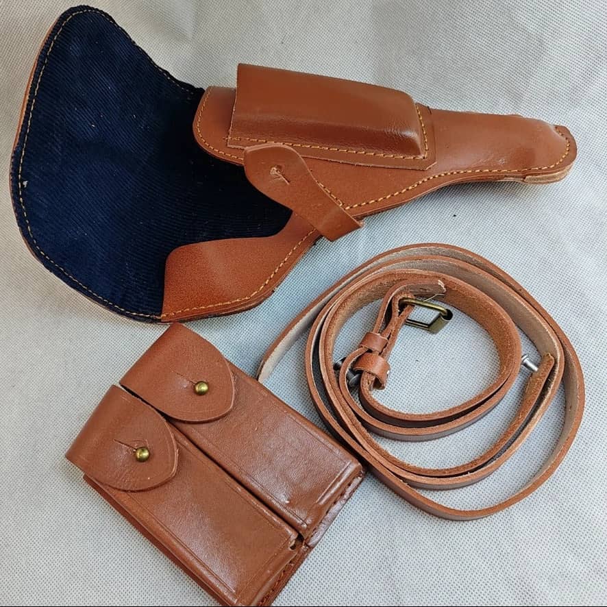 Brown leather pouch with strap on a beige background