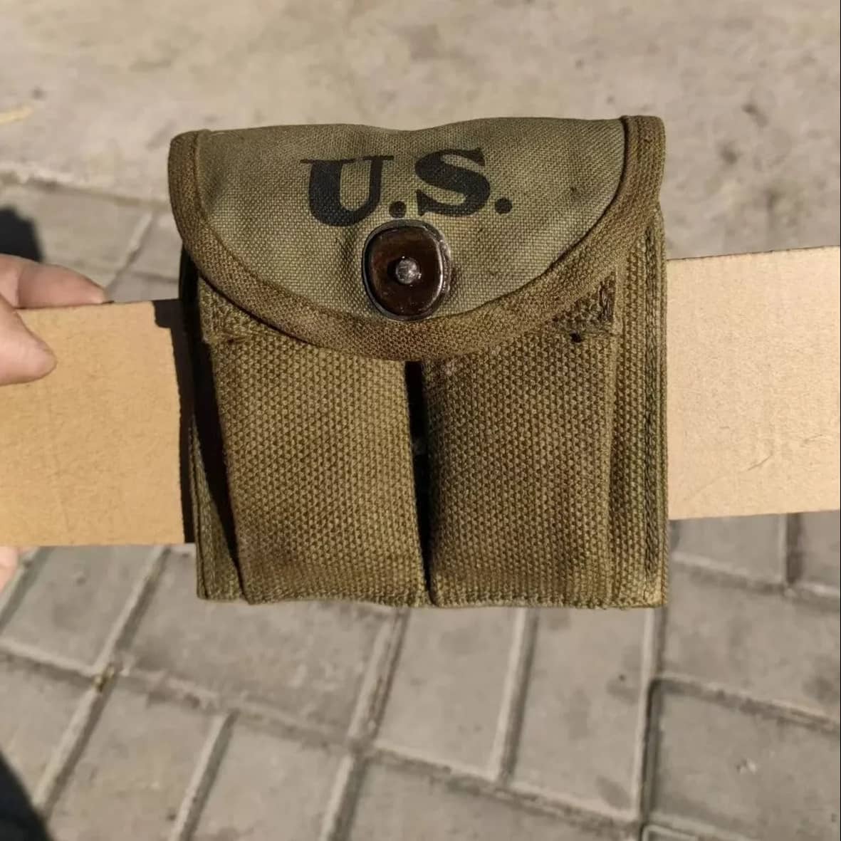 A small olive drab canvas pouch with 'U.S.