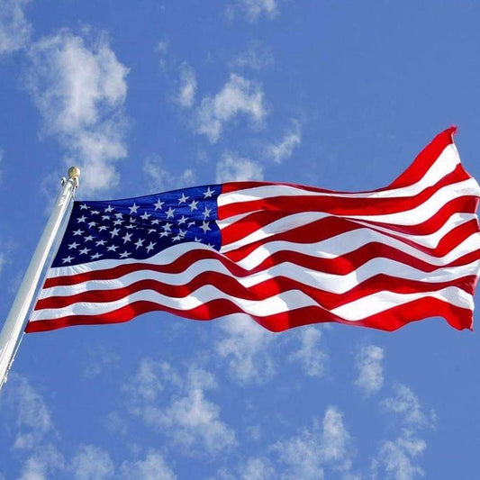 Vibrant USA flag outdoor waving against a blue sky with clouds, ideal for patriotic displays