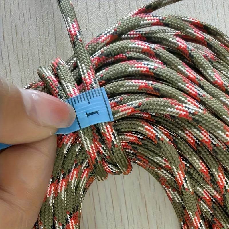 Colorful outdoor tent cord shown in a bundle with a hand holding part of it for easy camping setup