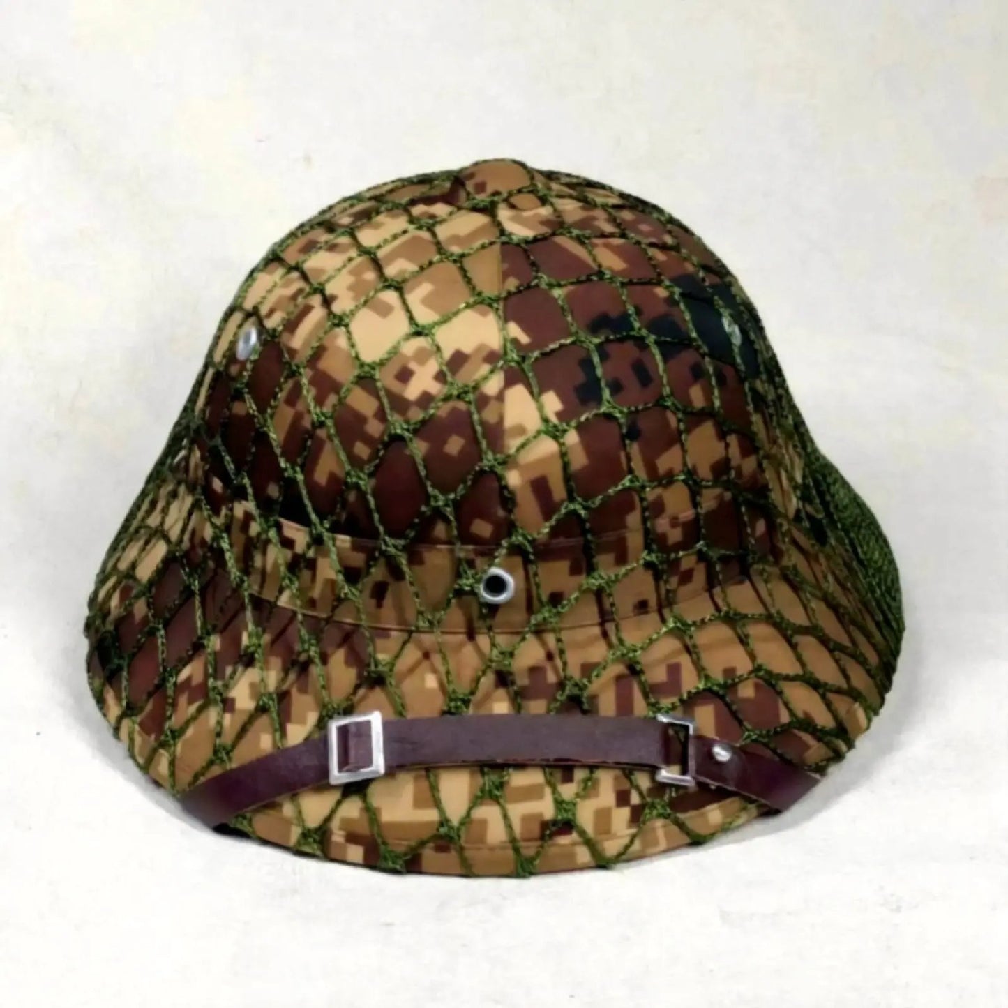 Camouflage-patterned bucket hat with a brown strap on a white background
