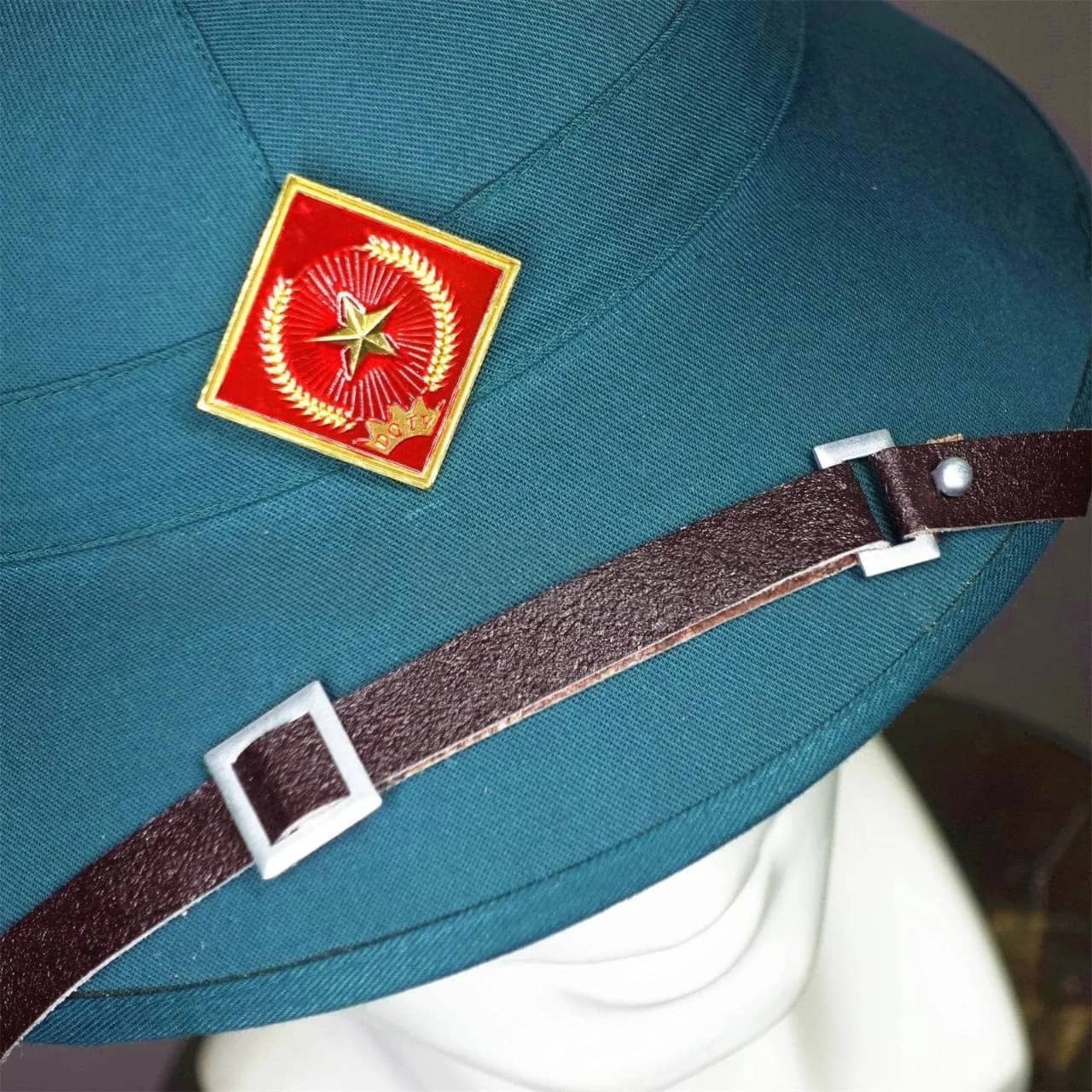 Vietnam surplus military helmet in green with a decorative emblem