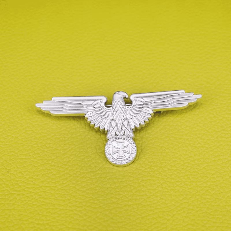 Silver WW2 German Luftwaffe badges with eagle design on a yellow background